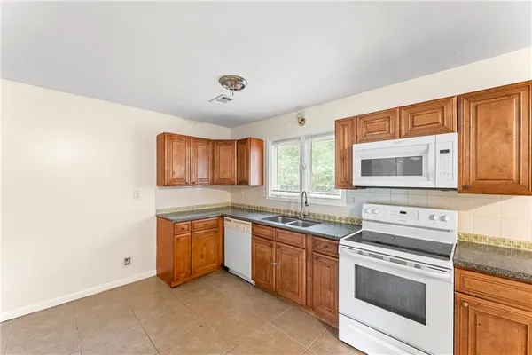 a kitchen with stainless steel appliances granite countertop a stove a sink and a microwave