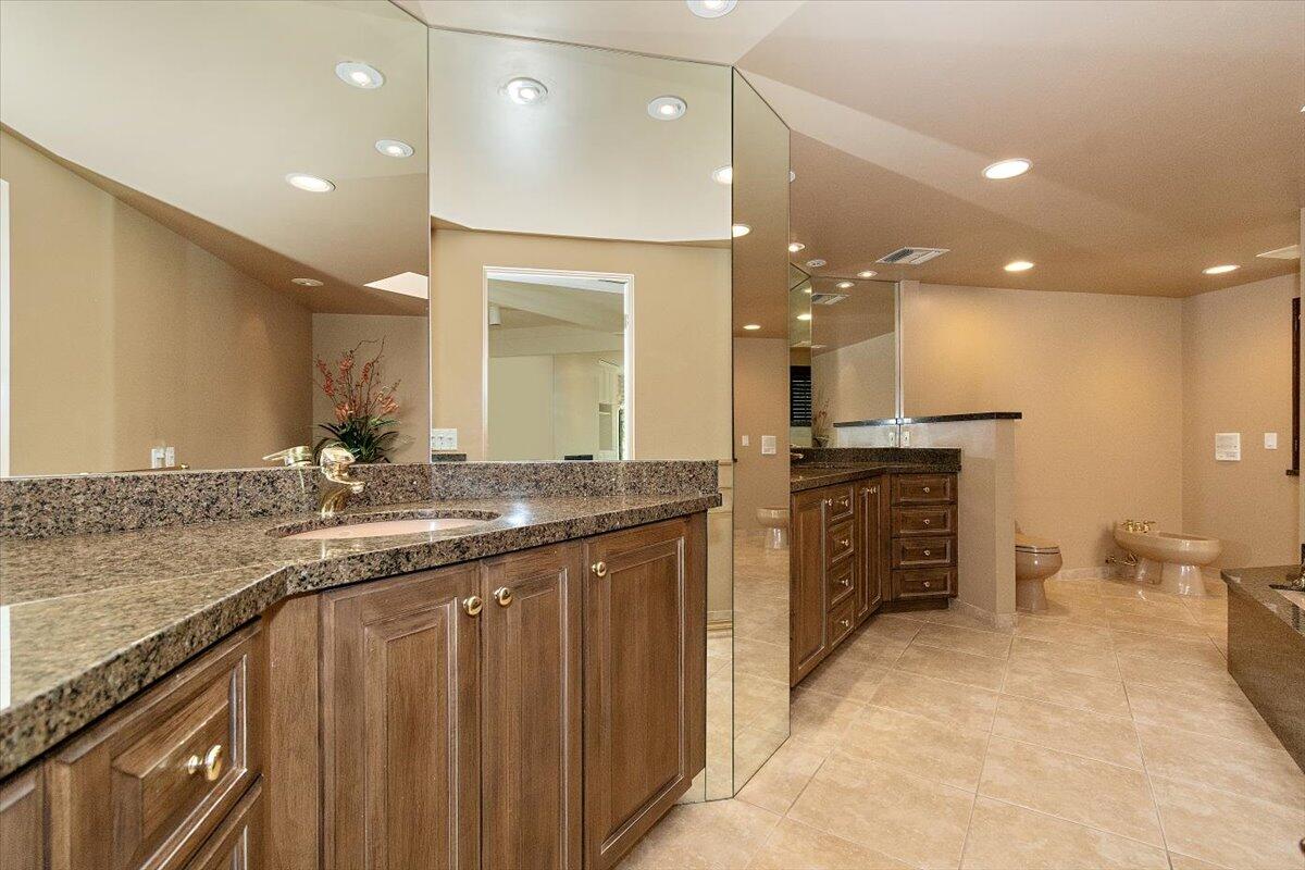 40885 Thunderbird Road Rancho Mirage, CA 92270 - Photo 34 of 61 a bathroom with a granite countertop sink a large mirror and a shower