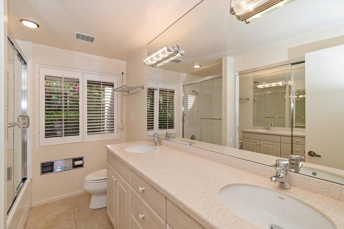 40885 Thunderbird Road Rancho Mirage, CA 92270 - Photo 42 of 61 a bathroom with a granite countertop sink toilet a large mirror and a large window