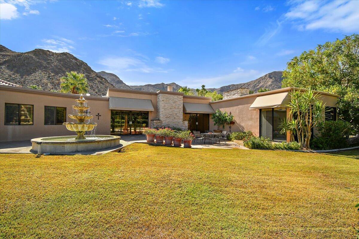 40885 Thunderbird Road Rancho Mirage, CA 92270 - Photo 47 of 61 a view of a swimming pool with a table and chairs under an umbrella