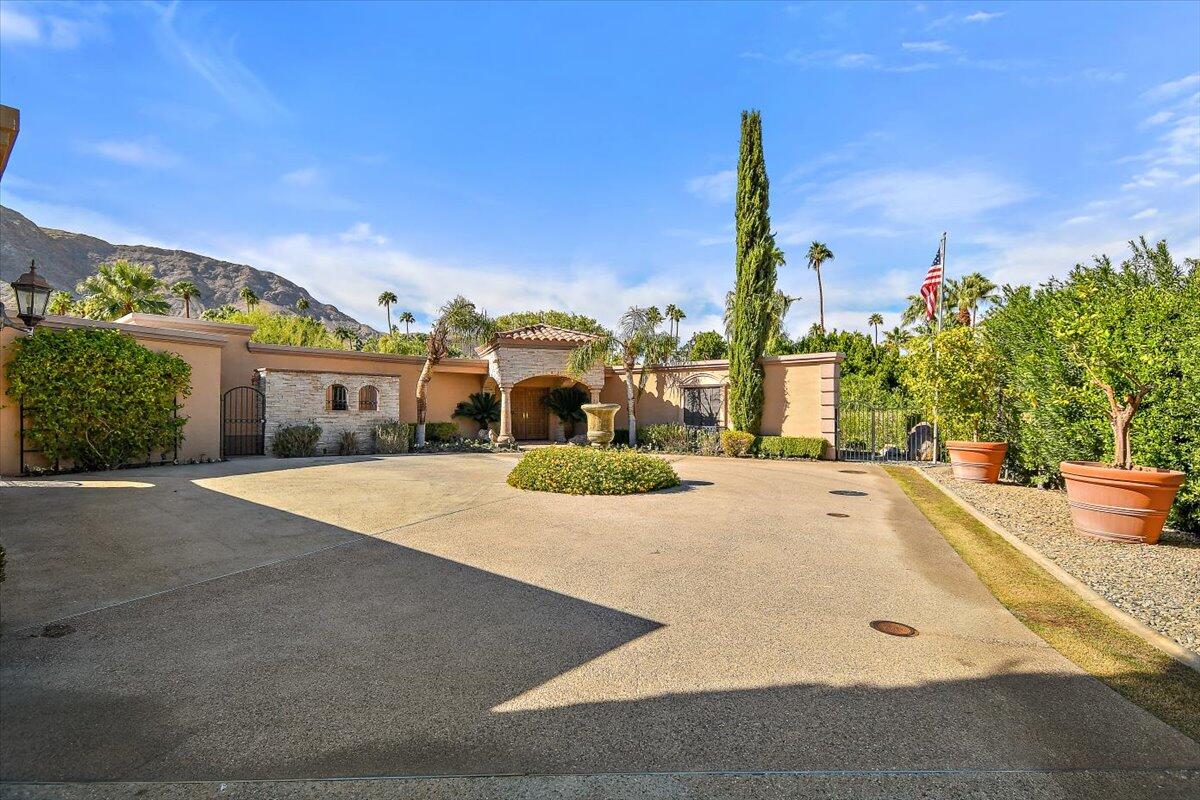 40885 Thunderbird Road Rancho Mirage, CA 92270 - Photo 49 of 61 a front view of a building with a garden and plants