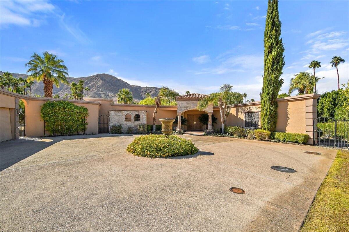 40885 Thunderbird Road Rancho Mirage, CA 92270 - Photo 5 of 61 a front view of a house with a yard and trees
