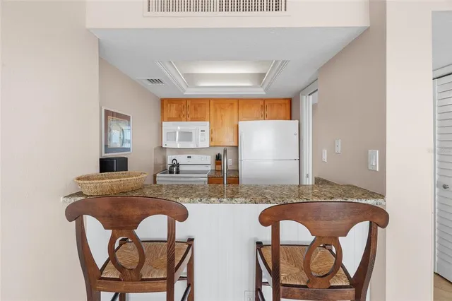 a dining room with two chairs and a granite counter tops