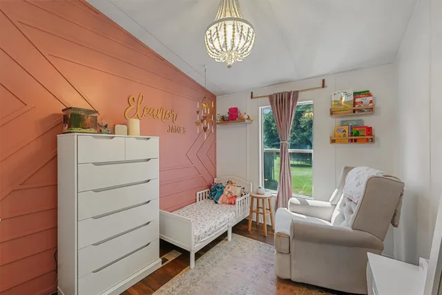 a bedroom with a bed and a chandelier