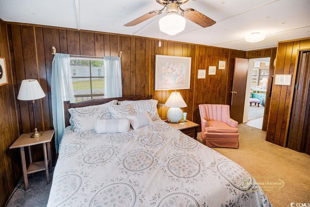 298 Flamingo Surfside Beach, SC 29575 - Photo 4 of 31 Carpeted bedroom featuring ceiling fan and wooden walls