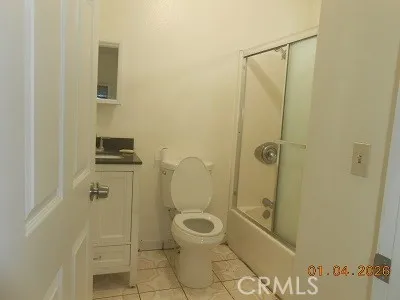 a bathroom with a granite countertop toilet a sink and shower