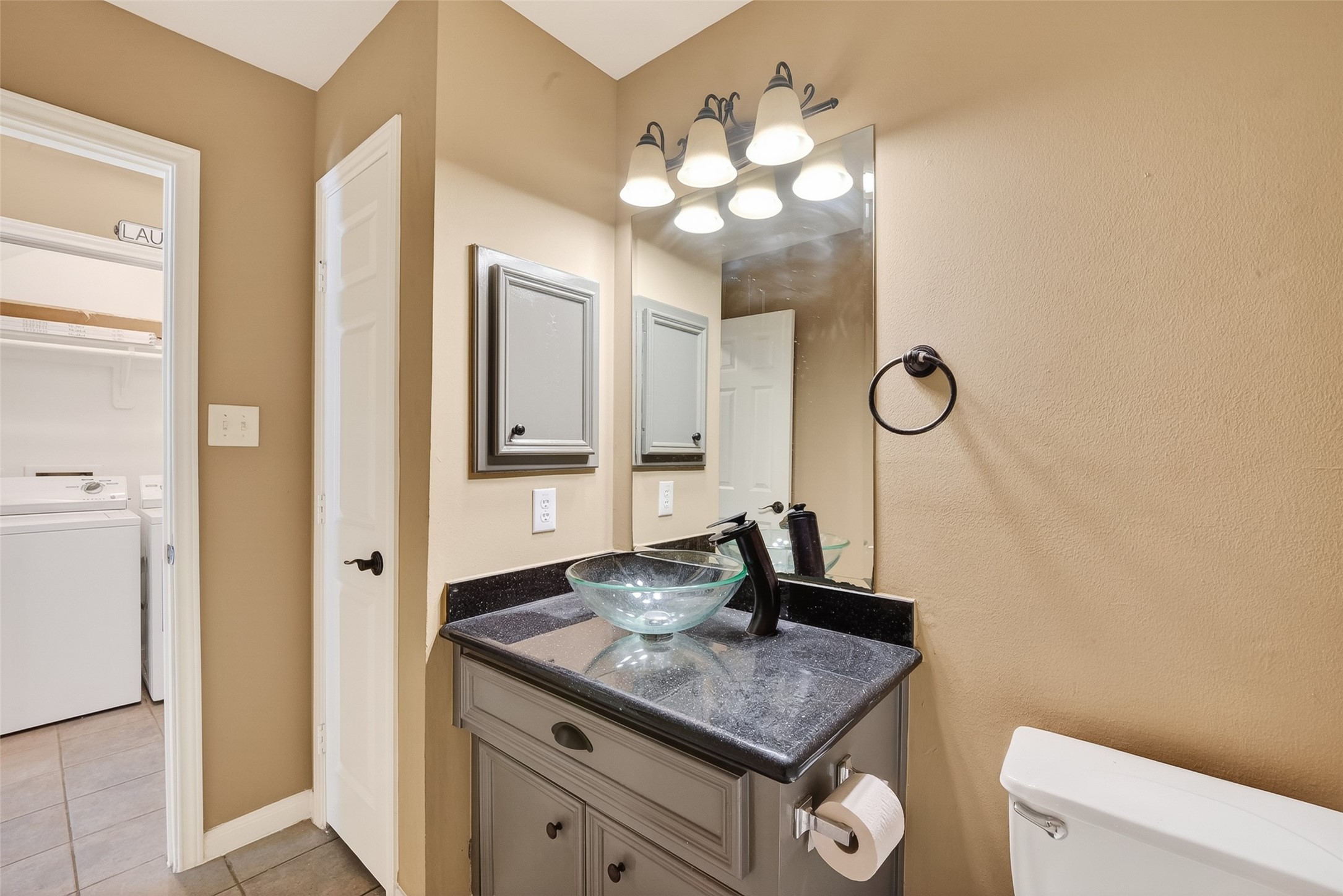 2804 Chenevert Street Houston, TX 77004 - Photo 8 of 37 a bathroom with a granite countertop sink a toilet and a mirror