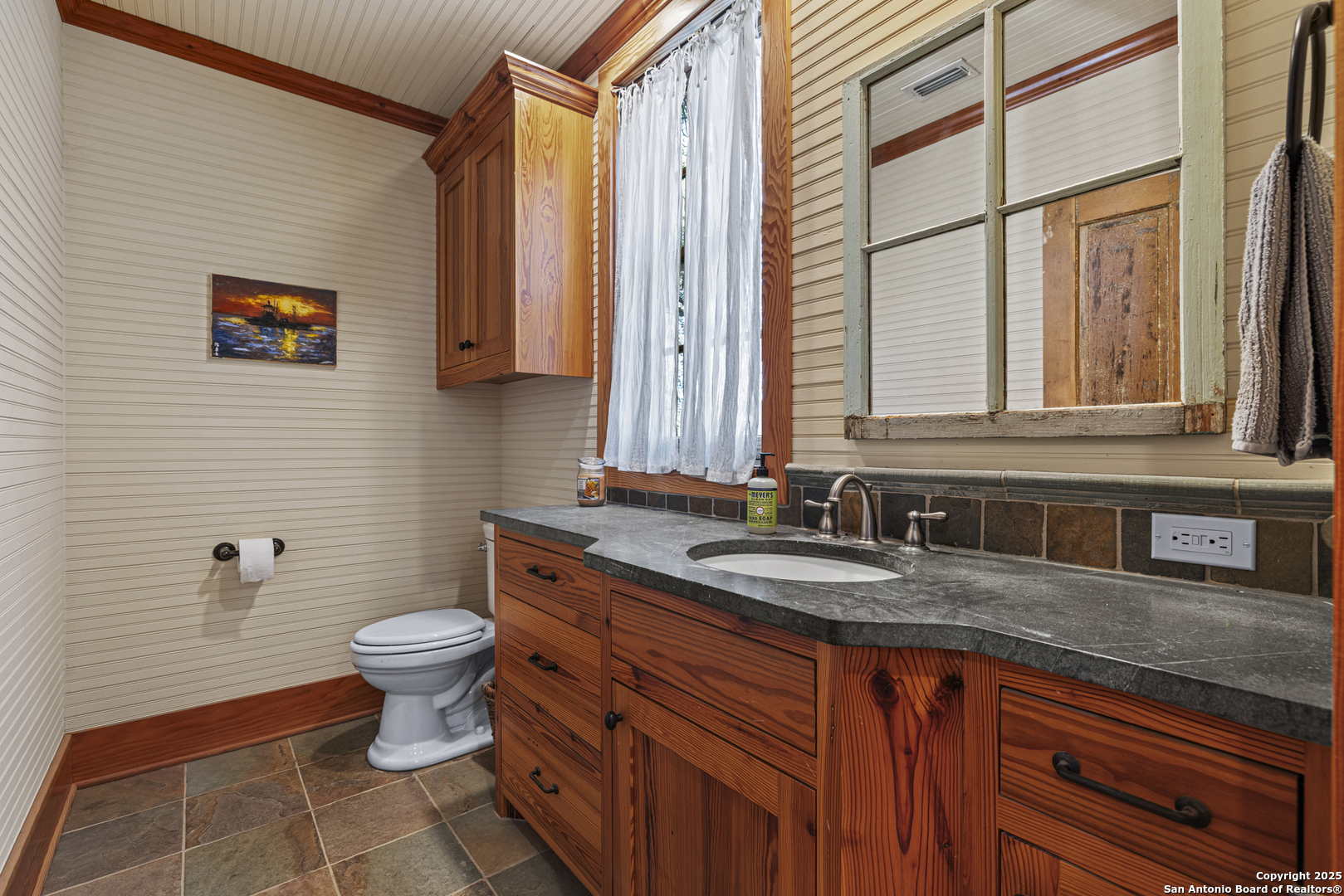 9402 Doss-Spring Creek Road Doss, TX 78618 - Photo 12 of 42 a bathroom with a granite countertop toilet a sink and a mirror