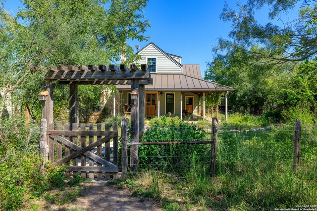 a view of a house with backyard sitting area and garden