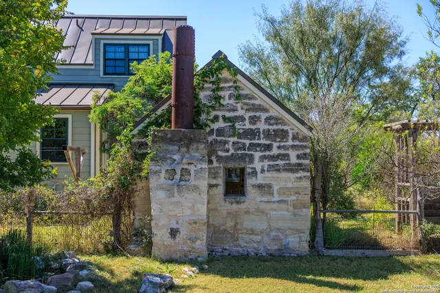 a view of house with backyard and glass windows