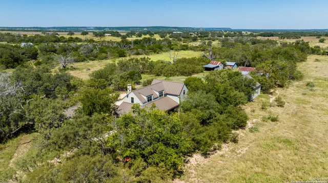 an aerial view of residential houses with outdoor space and trees