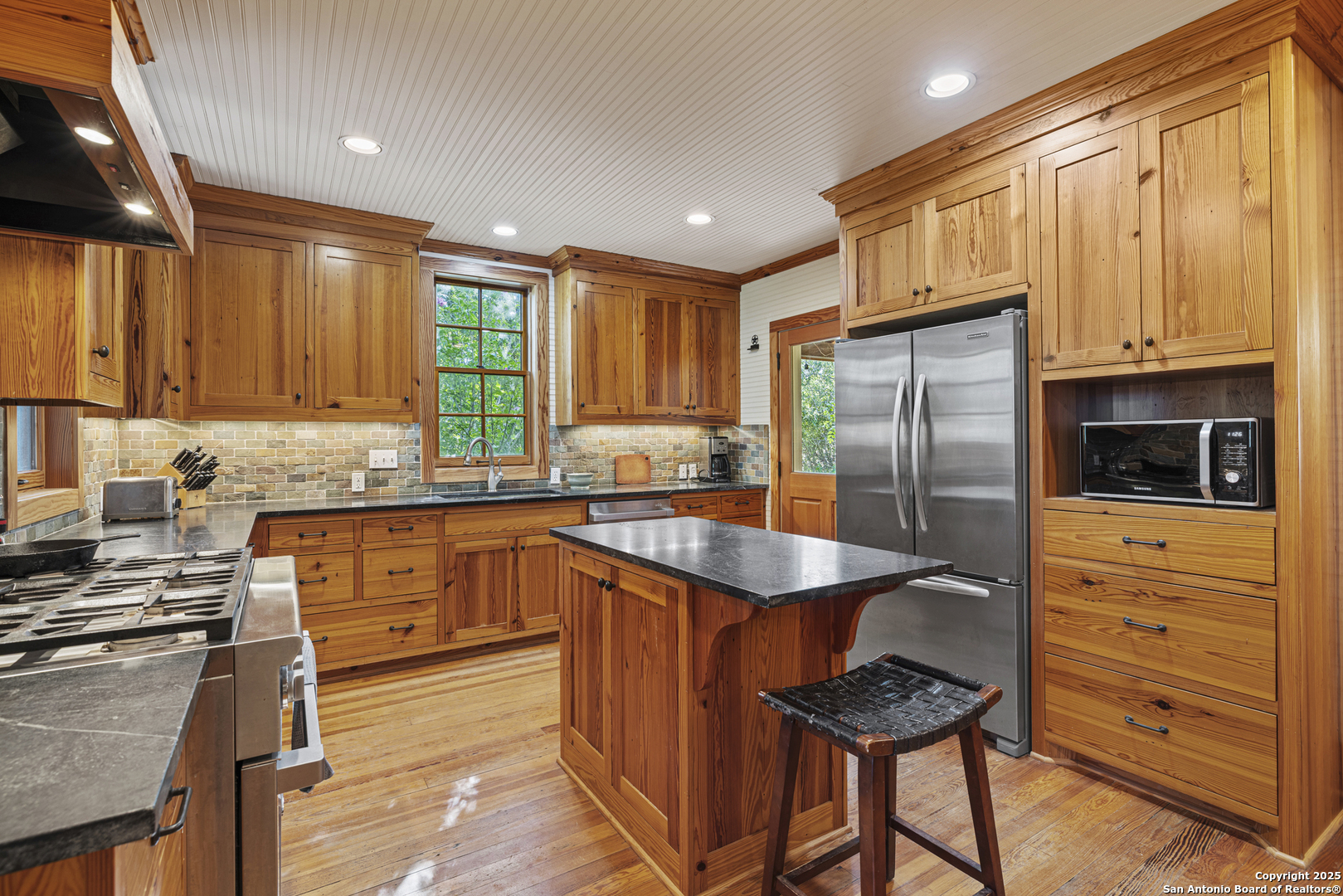 9402 Doss-Spring Creek Road Doss, TX 78618 - Photo 6 of 42 a kitchen with granite countertop a refrigerator stove top oven and sink