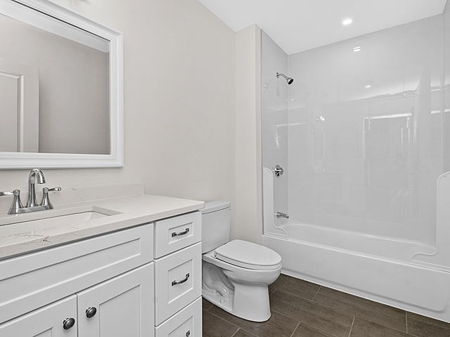 1 Pleasant Street, Unit 307 Cohasset, MA 02025 - Photo 3 of 24 a bathroom with a granite countertop toilet a sink and a bathtub