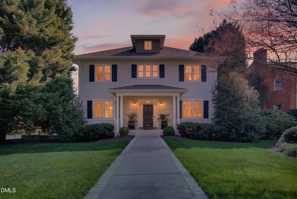 a front view of a house with a yard and garden