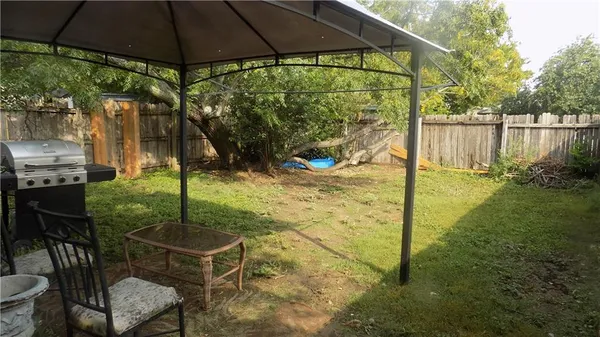 a backyard of a house with yard table and chairs