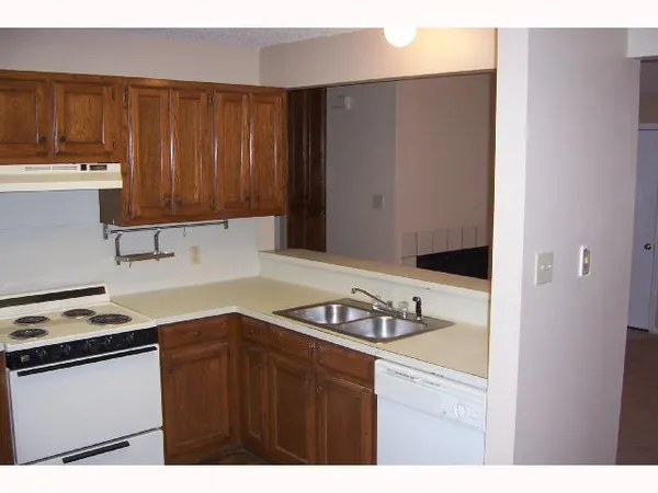 a kitchen with granite countertop a sink stove and cabinets