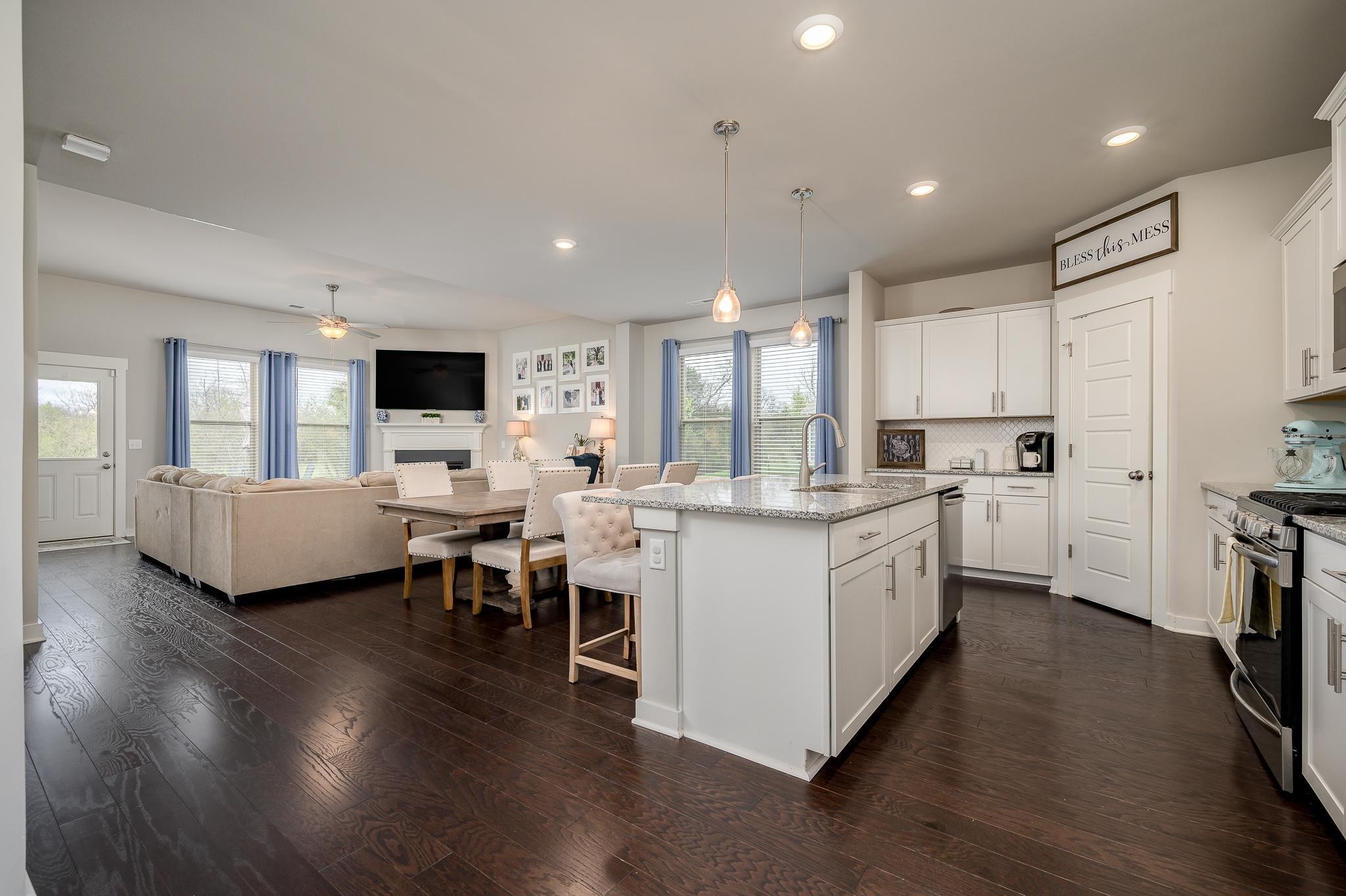 3130 Rift Lane Murfreesboro, TN 37130 - Photo 2 of 31 a kitchen with a sink dishwasher a stove a dining table and chairs with wooden floor