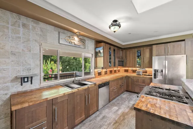 a kitchen with stainless steel appliances granite countertop a sink stove and refrigerator