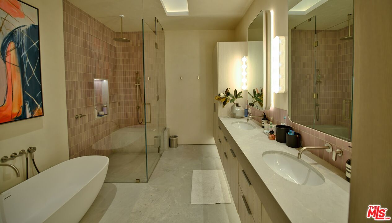 11531 Orum Road Los Angeles, CA 90049 - Photo 19 of 27 a bathroom with a tub a sink and mirrors