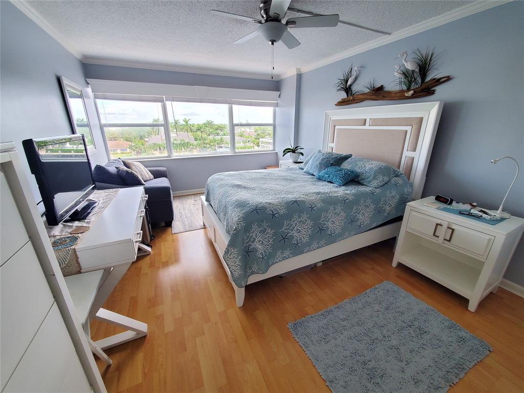2611 North Riverside Drive, Unit 504 Pompano Beach, FL 33062 - Photo 19 of 35 a bedroom with a bed and wooden floor