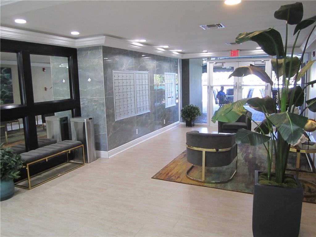 2611 North Riverside Drive, Unit 504 Pompano Beach, FL 33062 - Photo 2 of 35 a living room with furniture a potted plant and a kitchen view
