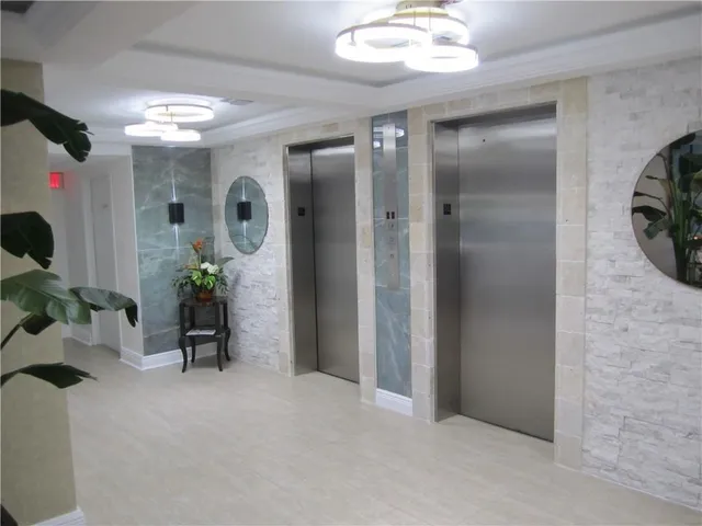 a view of a hallway with dining room and mirror