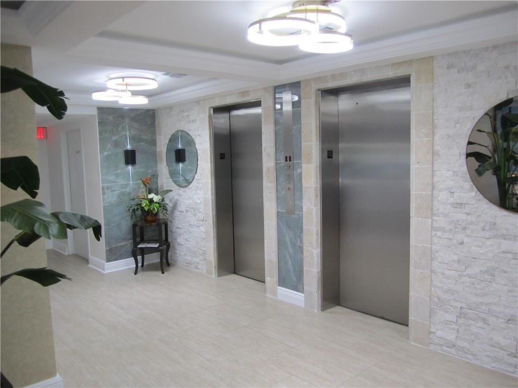 2611 North Riverside Drive, Unit 504 Pompano Beach, FL 33062 - Photo 4 of 35 a view of a hallway with dining room and mirror