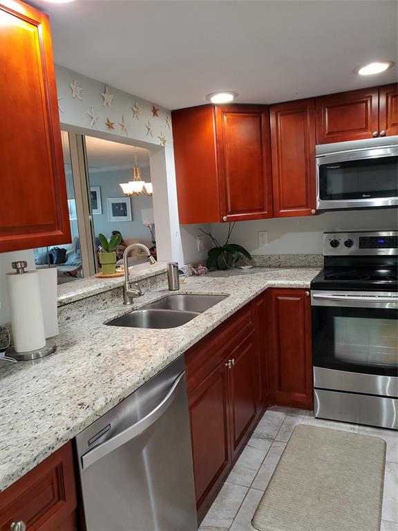 2611 North Riverside Drive, Unit 504 Pompano Beach, FL 33062 - Photo 7 of 35 a kitchen with stainless steel appliances granite countertop a sink a stove microwave and cabinets