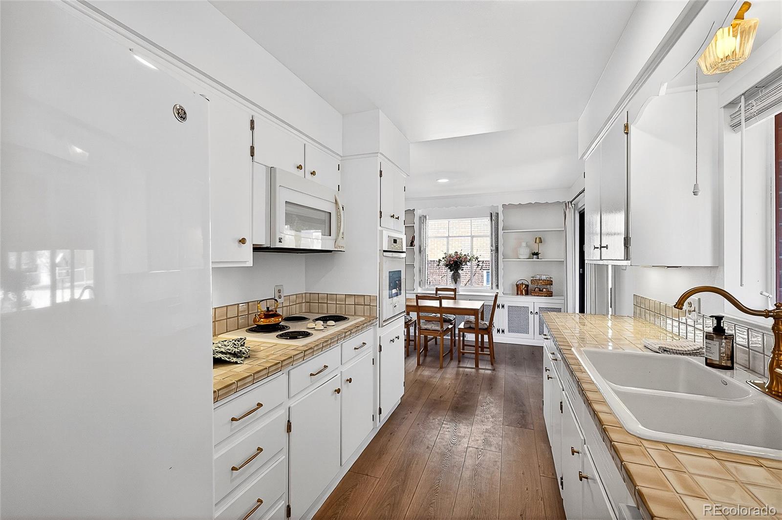 2768 South Mabry Way Denver, CO 80236 - Photo 13 of 39 a kitchen with granite countertop a sink stove and cabinets