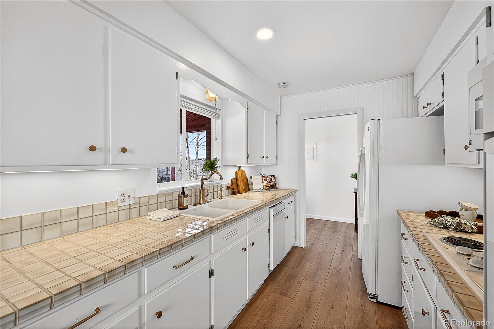 2768 South Mabry Way Denver, CO 80236 - Photo 10 of 39 a large white kitchen with a stove a sink dishwasher and a refrigerator
