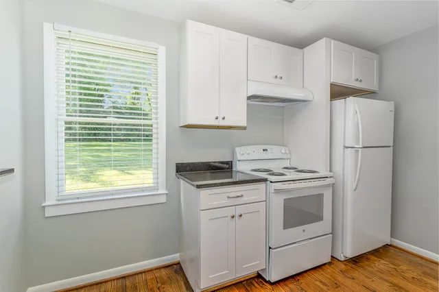 a kitchen with a stove a refrigerator and a window