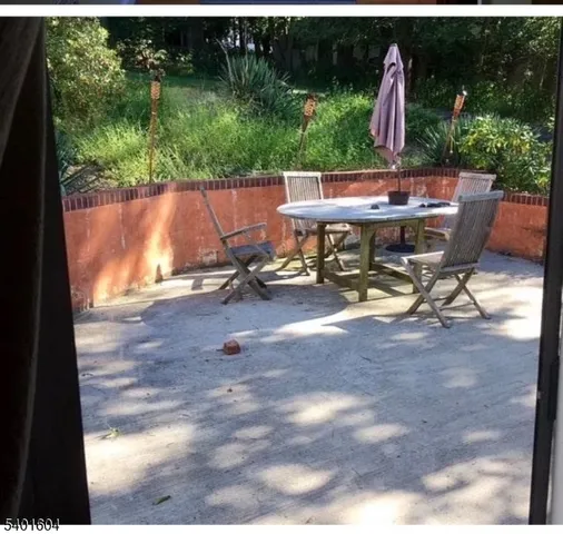 a view of a patio with table and chairs a barbeque with wooden fence