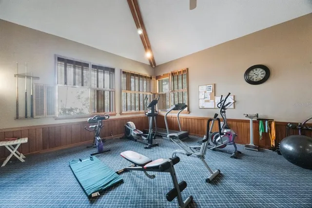 a view of a swimming pool with lawn chairs under an umbrella