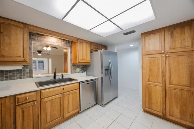 a kitchen with kitchen island white cabinets and refrigerator