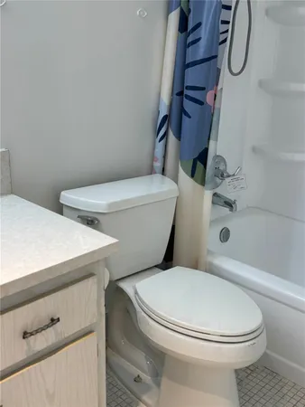 a white toilet sitting next to a bath tub