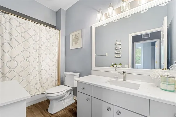 a bathroom with a sink a toilet and shower curtain