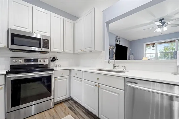 a kitchen with cabinets stainless steel appliances and a sink