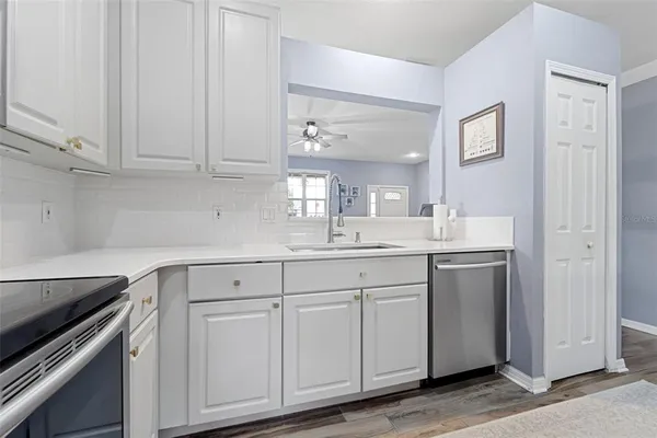 a kitchen with white cabinets and sink