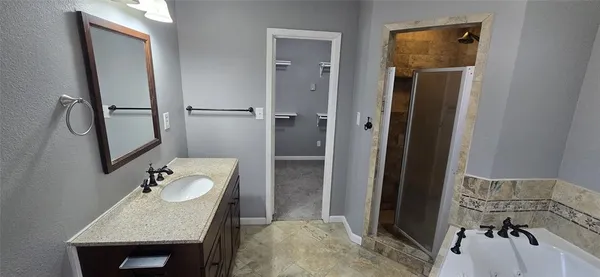 a bathroom with a sink vanity granite tub and shower