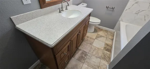 a bathroom with a sink a toilet and shower curtain