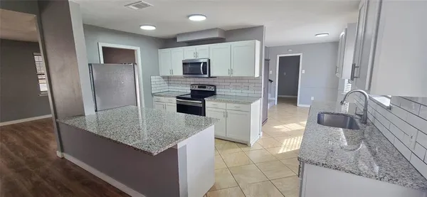 a kitchen with stainless steel appliances granite countertop a sink refrigerator and microwave