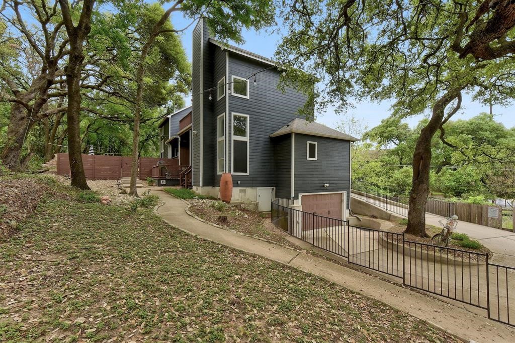 a view of a house with a large tree and wooden fence