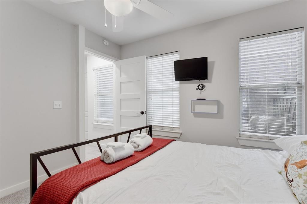 3201 South 5th Street, Unit B Austin, TX 78704 - Photo 13 of 25 a bedroom with a bed window and flat screen tv