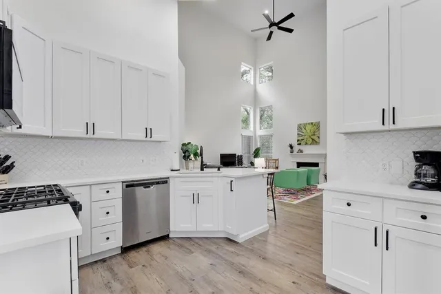 a kitchen with white cabinets and appliances