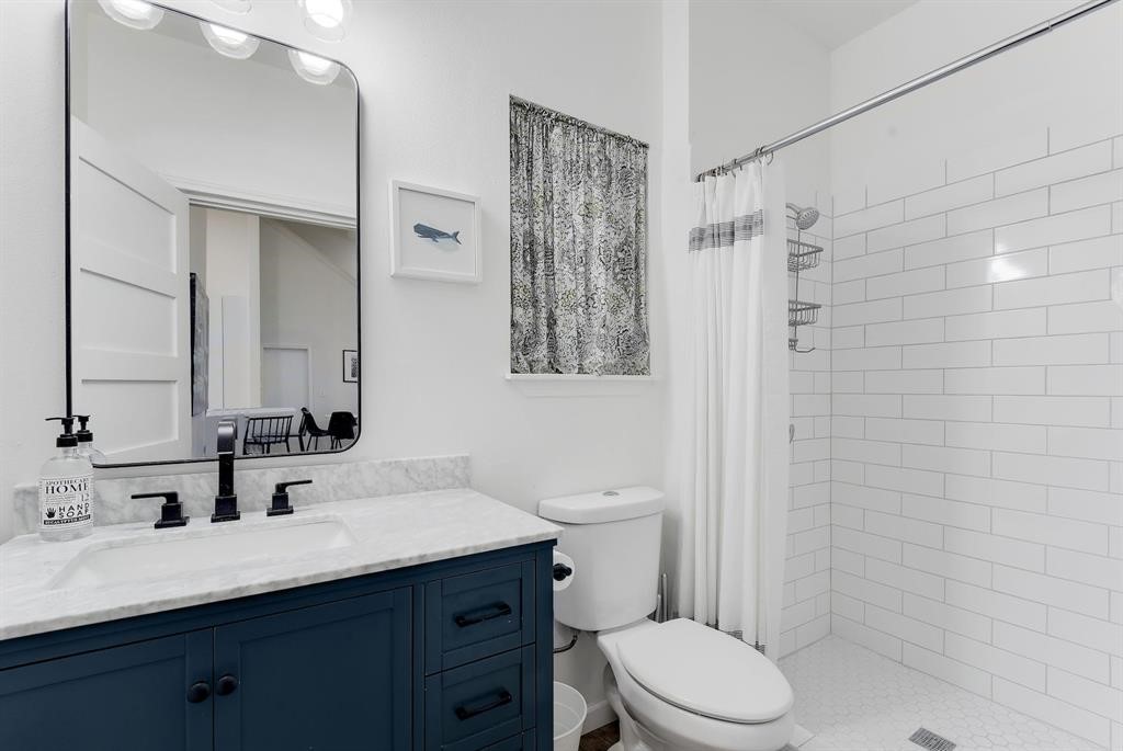 3201 South 5th Street, Unit B Austin, TX 78704 - Photo 20 of 25 a bathroom with a sink a toilet a shower and a mirror