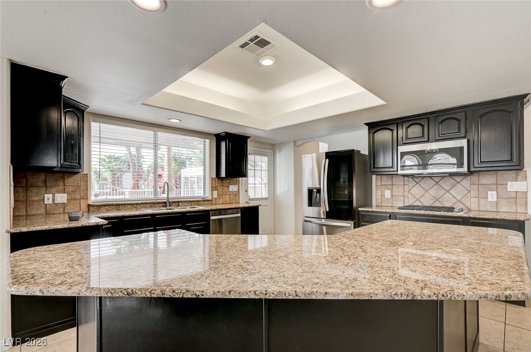 2955 El Camino Road Las Vegas, NV 89146 - Photo 30 of 99 Kitchen with tasteful backsplash, light stone countertops, dark cabinetry, and recessed lighting