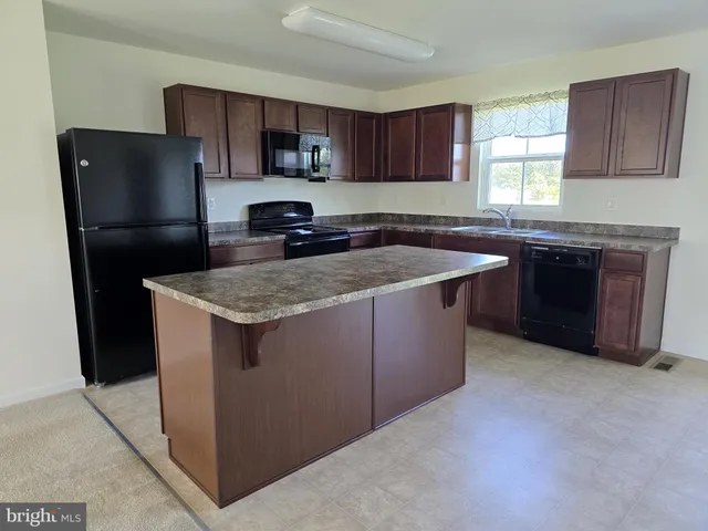 a kitchen with stainless steel appliances granite countertop a stove a refrigerator and a sink