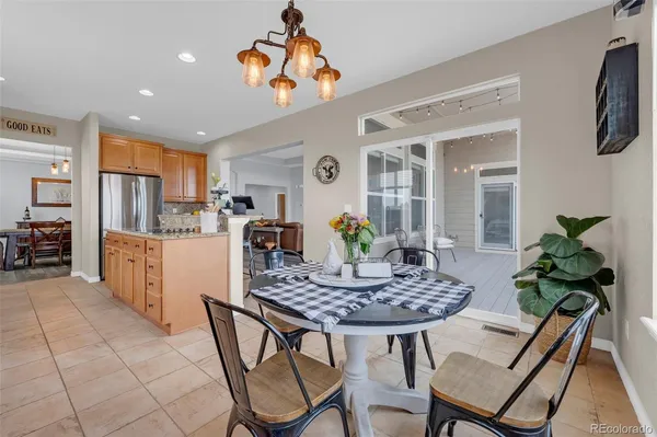 a dining room filled chandelier and kitchen view