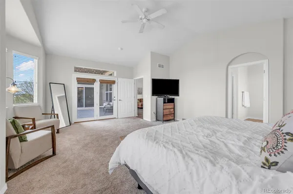 a large bedroom with a bed and a flat screen tv