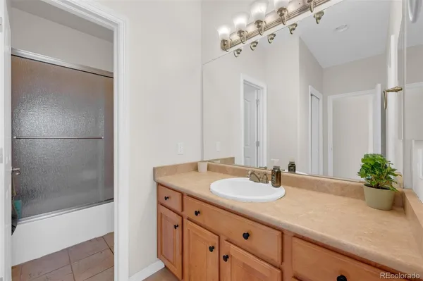 a bathroom with a granite countertop sink a mirror and a shower